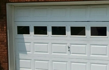 A white double garage panel door with windows