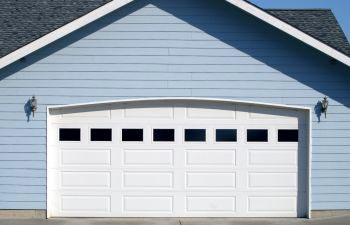 A residential double garage withwhite panel door with windows.